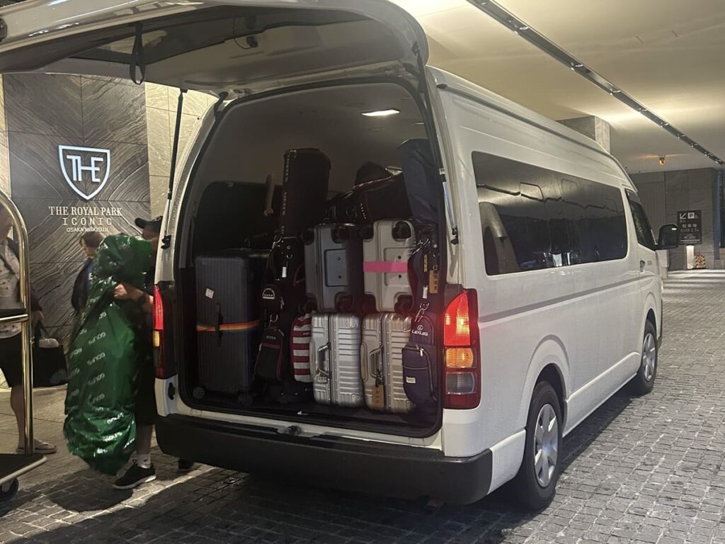 Toyota Hiace van fully loaded with suitcases at a hotel entrance